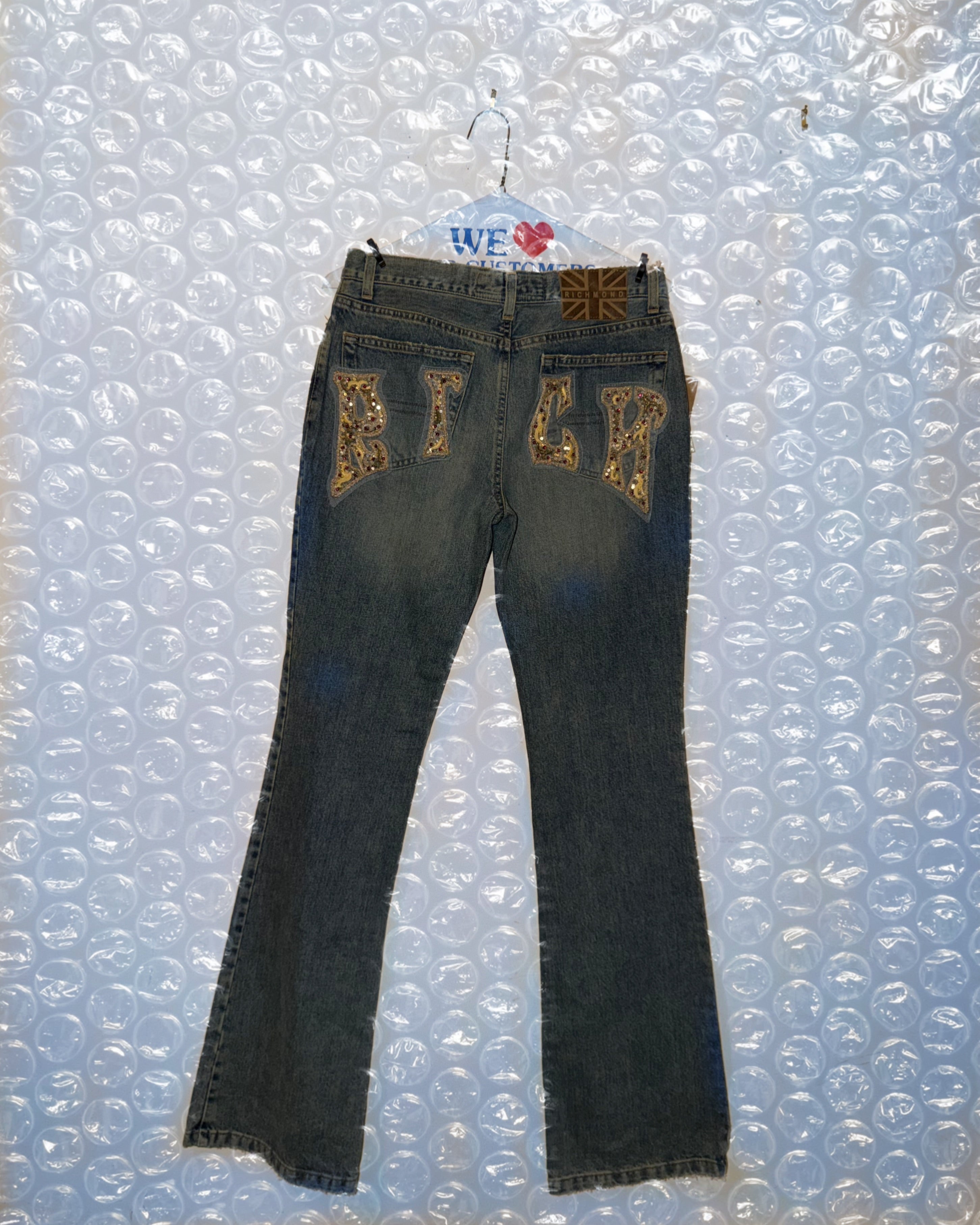 Black jeans with gold embroidery on a bubble wrap background